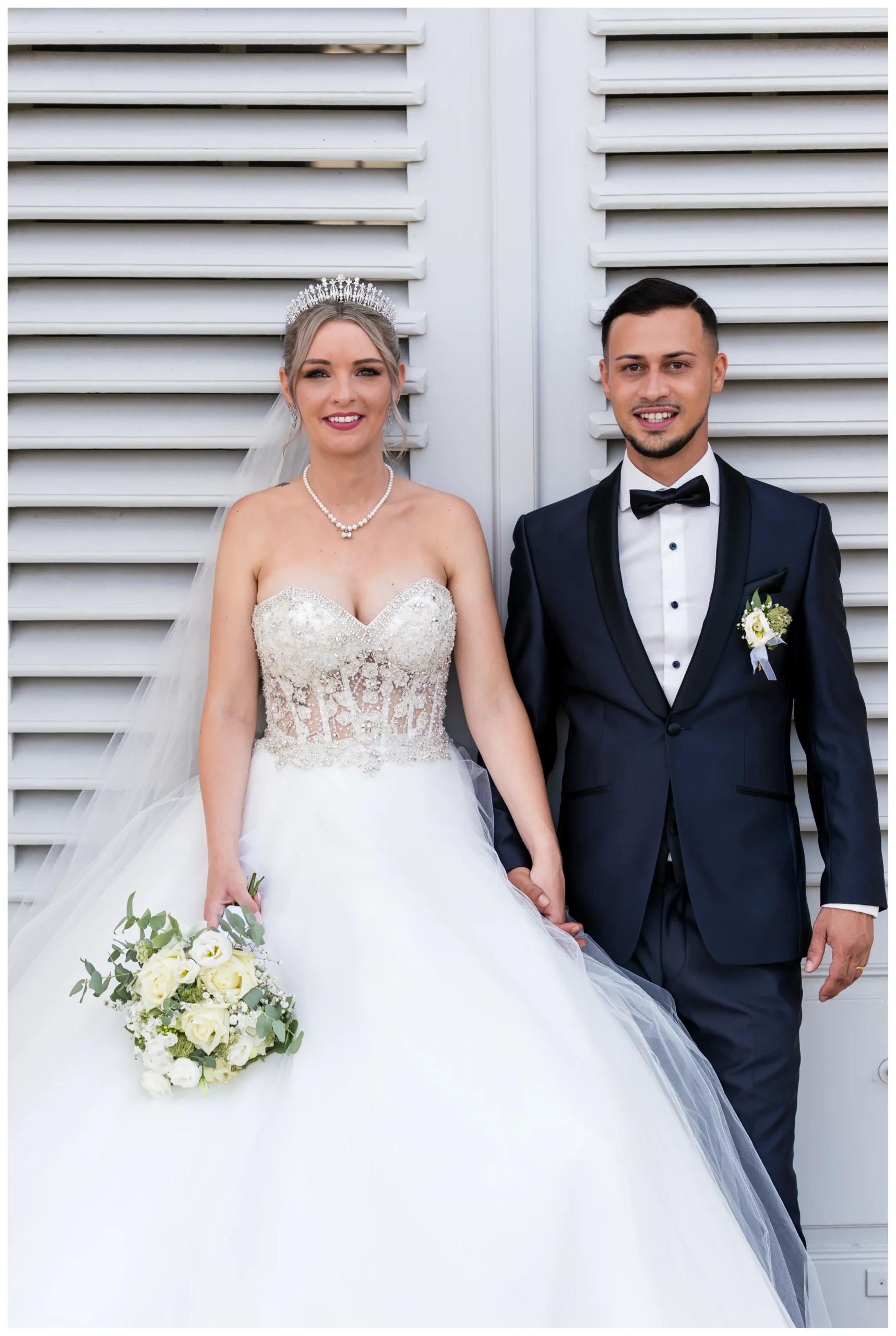 Nahaufnahme eines eleganten Brautpaares nach der kirchlichen Trauung beim Fotoshooting vor Schlosskulisse bei Stuttgart.