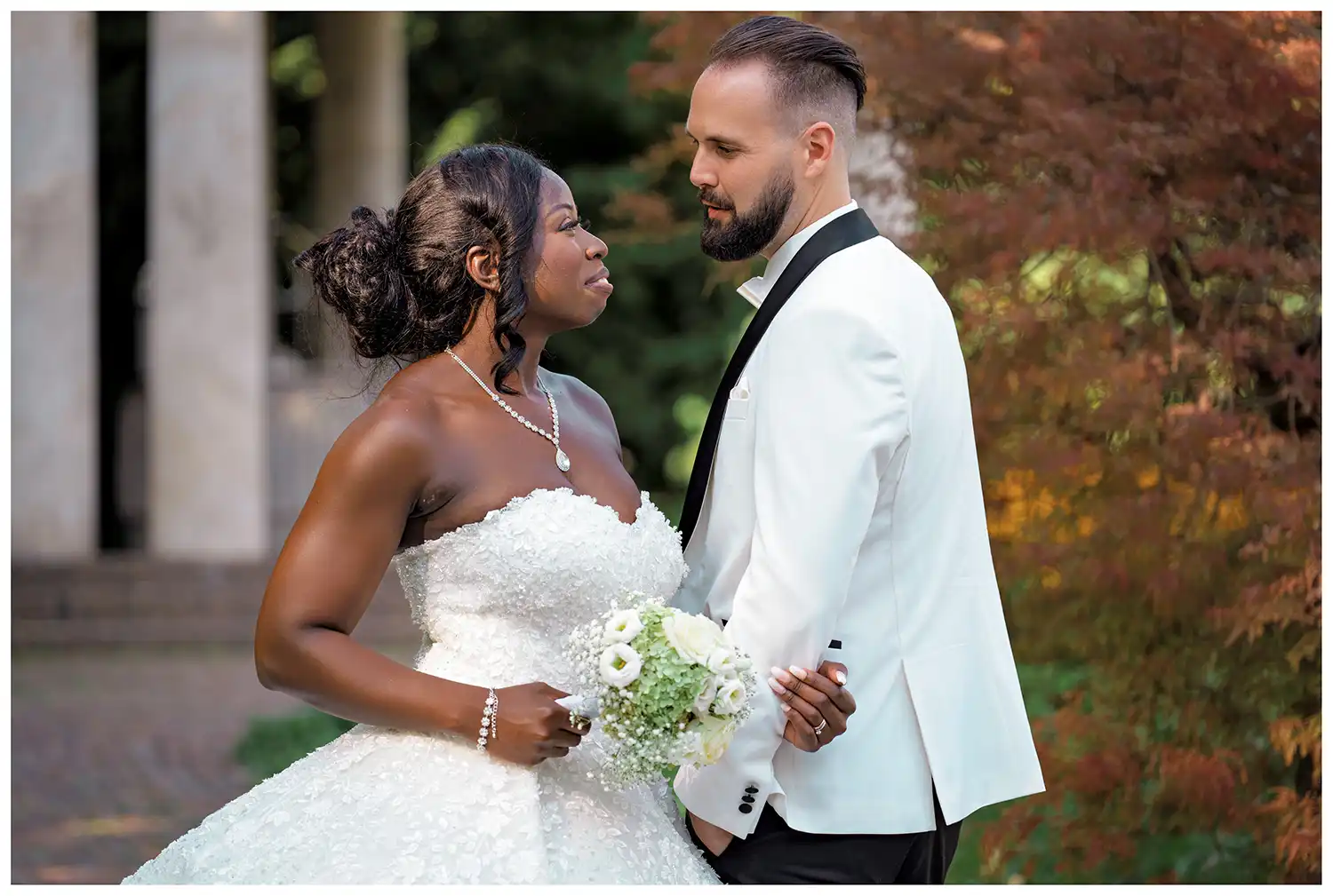 Elegantes Brautpaar beim Hochzeitsshooting im Kurpark Bad Überkingen mit schulterfreiem Brautkleid und hellem Anzug