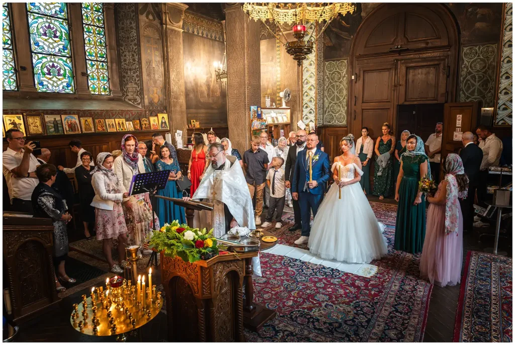 Brautpaar bei einer kirchlichen Trauung in der russisch-orthodoxen Kirche in Baden-Baden, umgeben von Familie und Freunden.